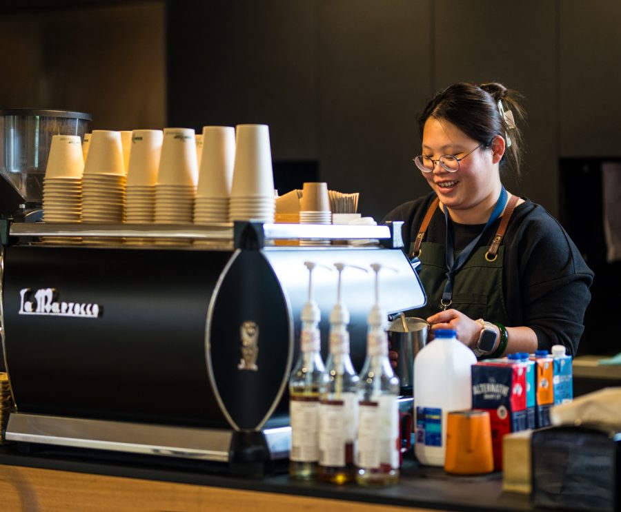 Barista making coffee behind the coffee maker.